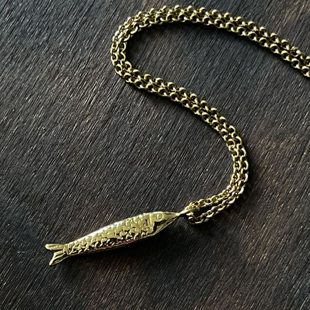 the jewel thief Brighton gold fish Necklace,  gold Sardine Necklace shown on a gold trace chain.