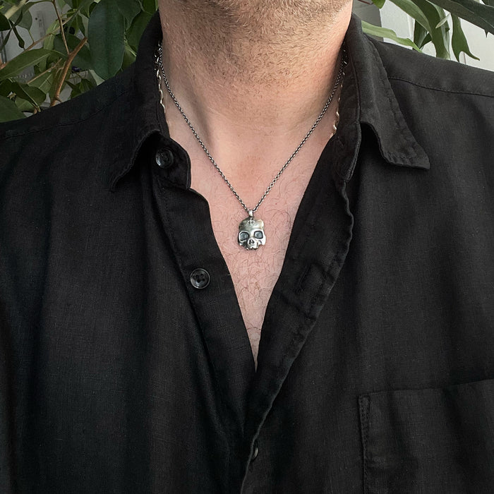 double-sided flat skull pendant worn by a male model, made by jewel thief Brighton.