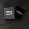 Bracelet in a 'Jewel Thief' branded box on a dark surface